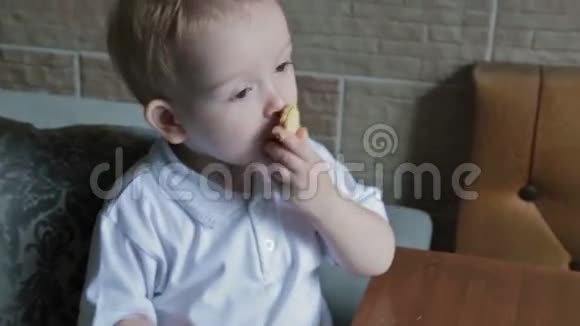 一个金发小男孩在厨房吃圆片视频的预览图