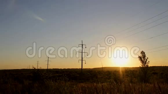 日落时分美丽的景色笼罩着高压电力线路视频的预览图