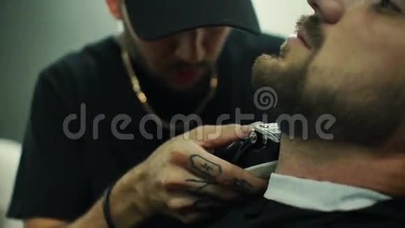 变得完美理发店理发师剪胡子的年轻留胡子男子的近景视频的预览图