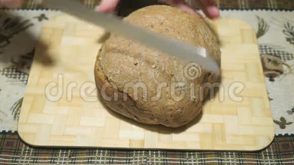 黑麦面包用一把刀切在木板上视频的预览图