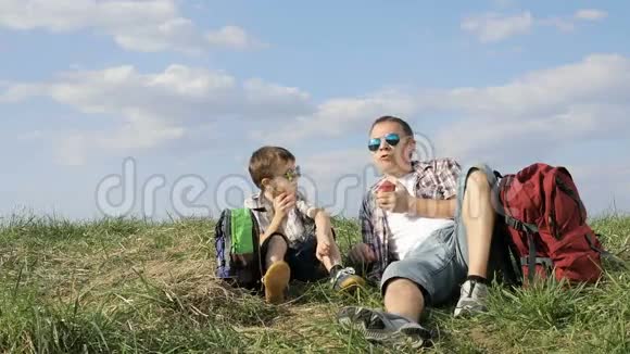 父亲和儿子在白天坐在田野里视频的预览图