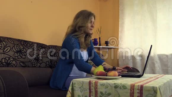 孕妇在家工作手提电脑葡萄水果花瓶视频的预览图