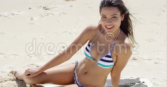 快乐的笑女坐在沙滩上视频的预览图