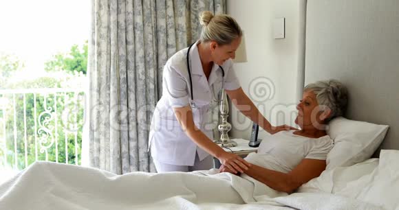 女医生在卧室的床上安慰老女人视频的预览图