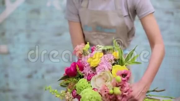 美丽的年轻女花匠拿着花束在墙上视频的预览图