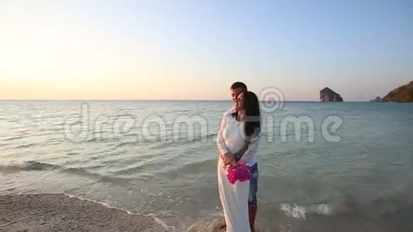 新娘新郎拥抱赤脚站在岛上视频的预览图