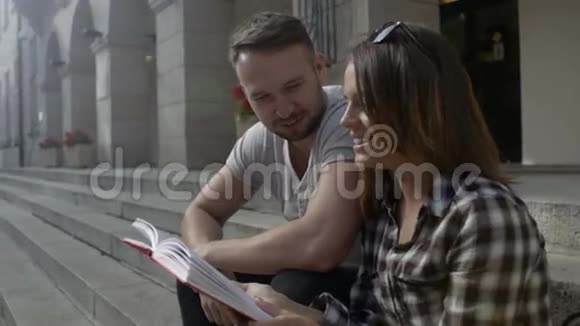 年轻夫妇一起读书坐在大学楼梯上户外视频的预览图