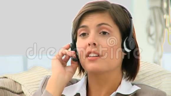 可爱的女商人在耳机上讲话视频的预览图