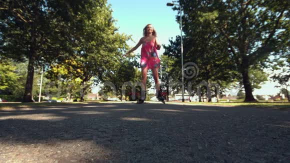 微笑的金发女郎在公园滑冰视频的预览图