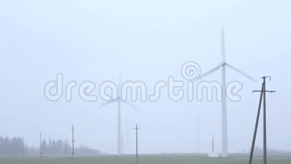 雾蒙蒙的早晨靠近公路的风车视频的预览图