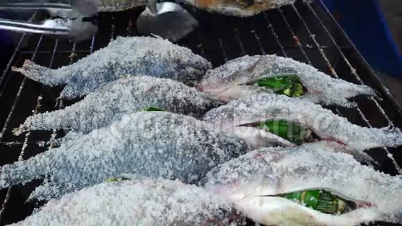 生罗非鱼烤串在热烤木炭上视频的预览图