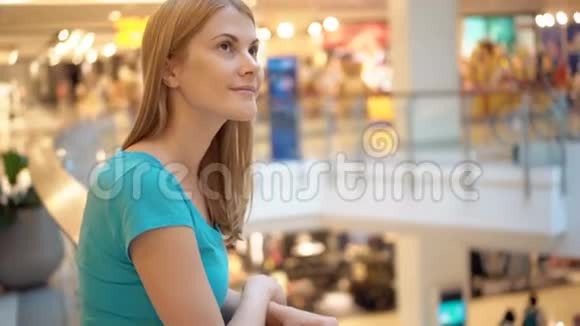 年轻漂亮迷人的女人站在购物中心微笑着购物消费主义概念视频的预览图
