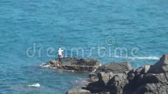 一个人用一块巨大的石头在公海捕鱼大海又干净又蓝视频的预览图