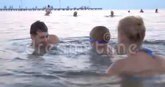 男孩和父母一起在海里游泳视频的预览图