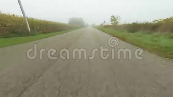 在雾蒙蒙的一天从一个角度沿着一条安静的道路行驶视频的预览图