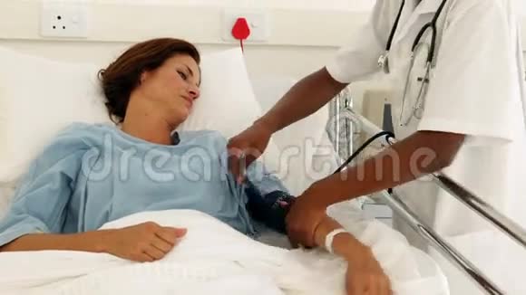 病房里微笑的护士和她的病人说话视频的预览图