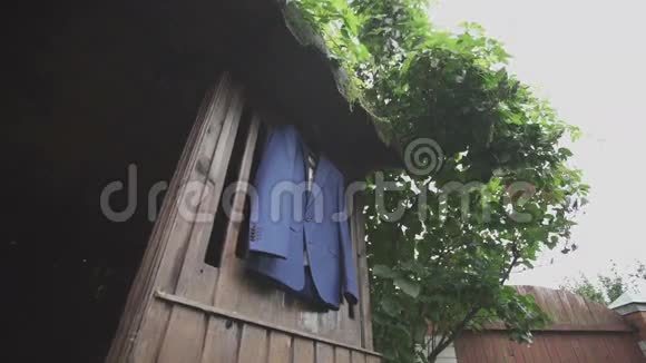 挂在木头背景上的蓝色夹克视频的预览图