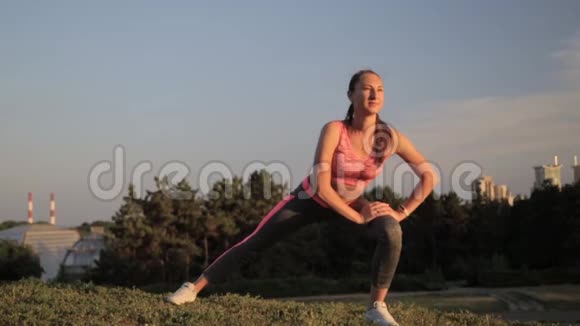 时尚运动服装中的健身时髦女孩在街上做瑜伽健身运动户外运动视频的预览图