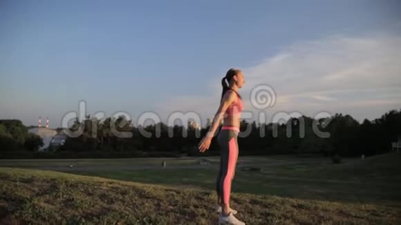 时尚运动服装中的健身时髦女孩在街上做瑜伽健身运动户外运动视频的预览图