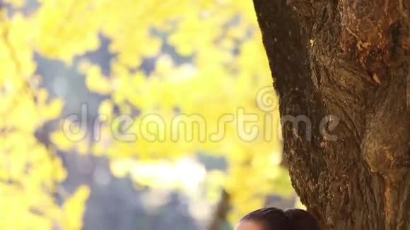 一位深褐色头发的美女靠在树上唱歌视频的预览图