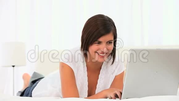 随意的棕色头发的女人用笔记本电脑视频的预览图