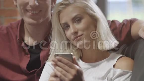 年轻夫妇在现代阁楼内部用手机看照片视频的预览图