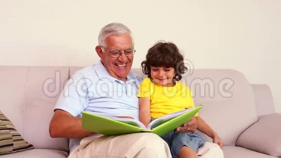 老人和孙子坐在沙发上看相册视频的预览图
