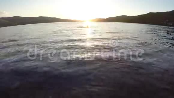 日落时分美丽的女人在海里游泳视频的预览图