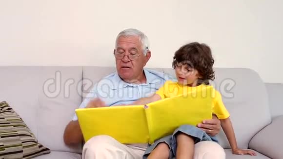老人和孙子坐在沙发上看相册视频的预览图