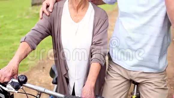 在公园里骑自行车的退休夫妇视频的预览图
