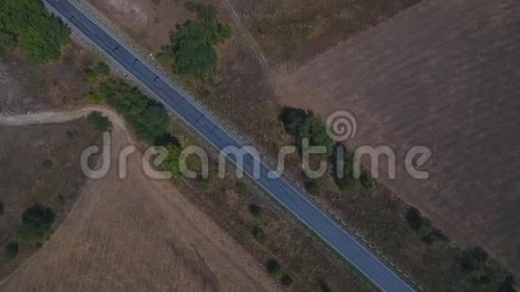 鸟瞰村庄道路和收获田野视频的预览图