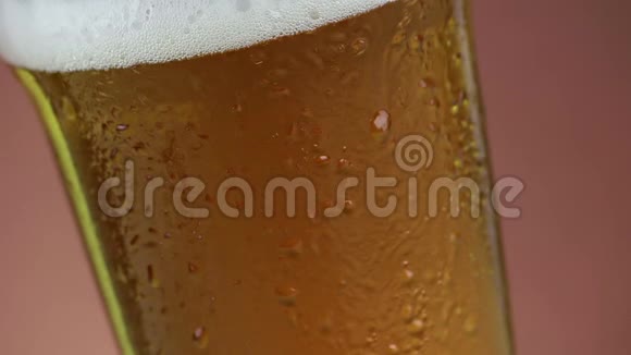 新鲜啤酒与泡沫进入饮料品脱杯与冰冻滴金棕色背景乐趣和营养食品和饮料视频的预览图