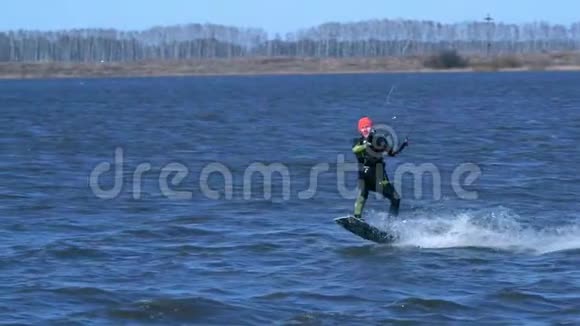 慢动作一个男性放风筝者沿着河骑在木板上他在水上活动时做各种练习视频的预览图