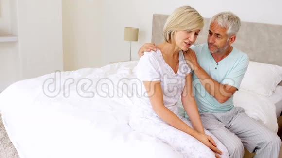 丈夫安慰坐在床上的妻子视频的预览图