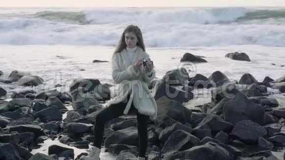 惊涛骇浪的海边的女摄影师拍照留念游客摄影师拍摄海洋图片视频的预览图