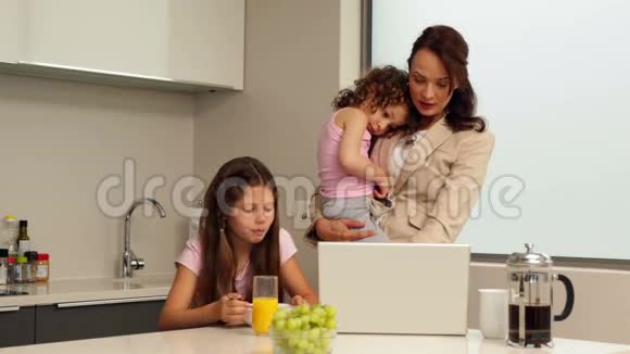 微笑着工作的母亲和她的孩子吃早餐视频的预览图