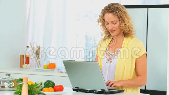 卷发女人看着食谱视频的预览图