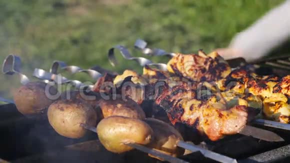 烤串上的烤串和土豆在烤炉里的煤上煮熟视频的预览图