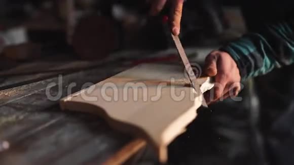 一个木匠在他的车间里用一个文件在木制窗框上工作视频的预览图