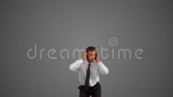 商人在灰色背景下跳跃和听音乐视频的预览图
