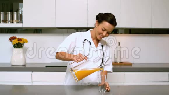 家庭护士在厨房里倒橙汁视频的预览图