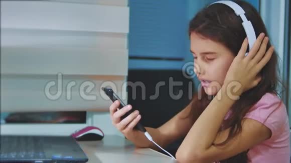小女孩在智能手机上耳机听音乐生活方式青少年女孩在播放列表音乐视频的预览图