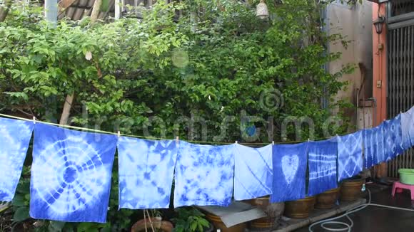 泰国妇女在阳光下系蜡染靛蓝颜色的悬挂工艺干衣视频的预览图
