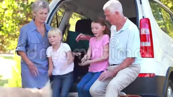 坐在车尾箱上的幸福家庭视频的预览图