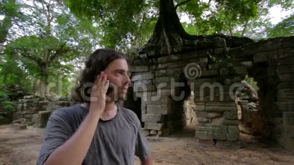 高加索游客用手机交谈热带丛林废墟视频的预览图