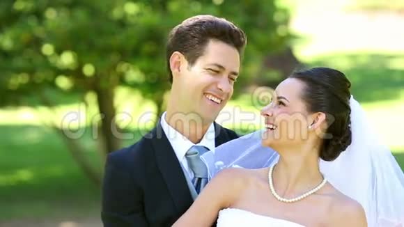 快乐的新婚夫妇在公园里互相拥抱视频的预览图