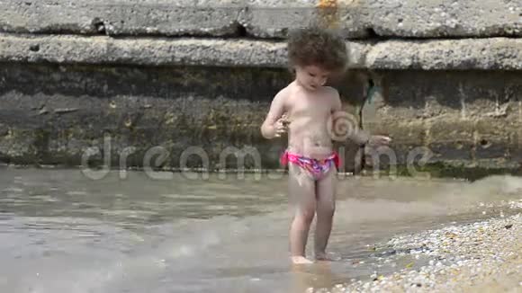 美丽的宝贝孩子在海边玩得清爽股票视频视频的预览图
