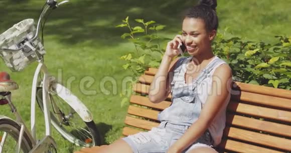 可爱的女人在公园里聊天智能手机视频的预览图
