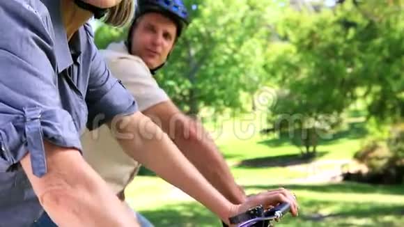 快乐的一对夫妇去公园骑自行车视频的预览图