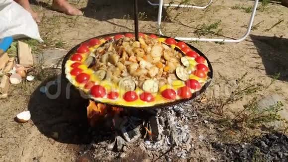 在阳光明媚的夏日在篝火上吃土豆和蔬菜视频的预览图